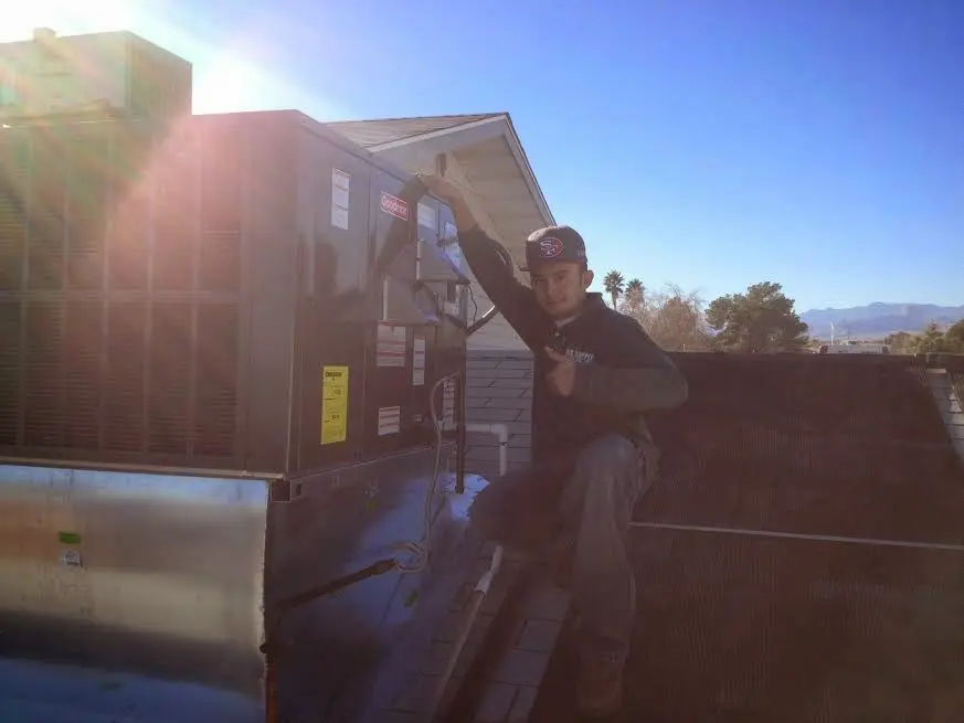 HVAC technician performing AC Tune-Up on a rooftop unit in Sugarmill Woods